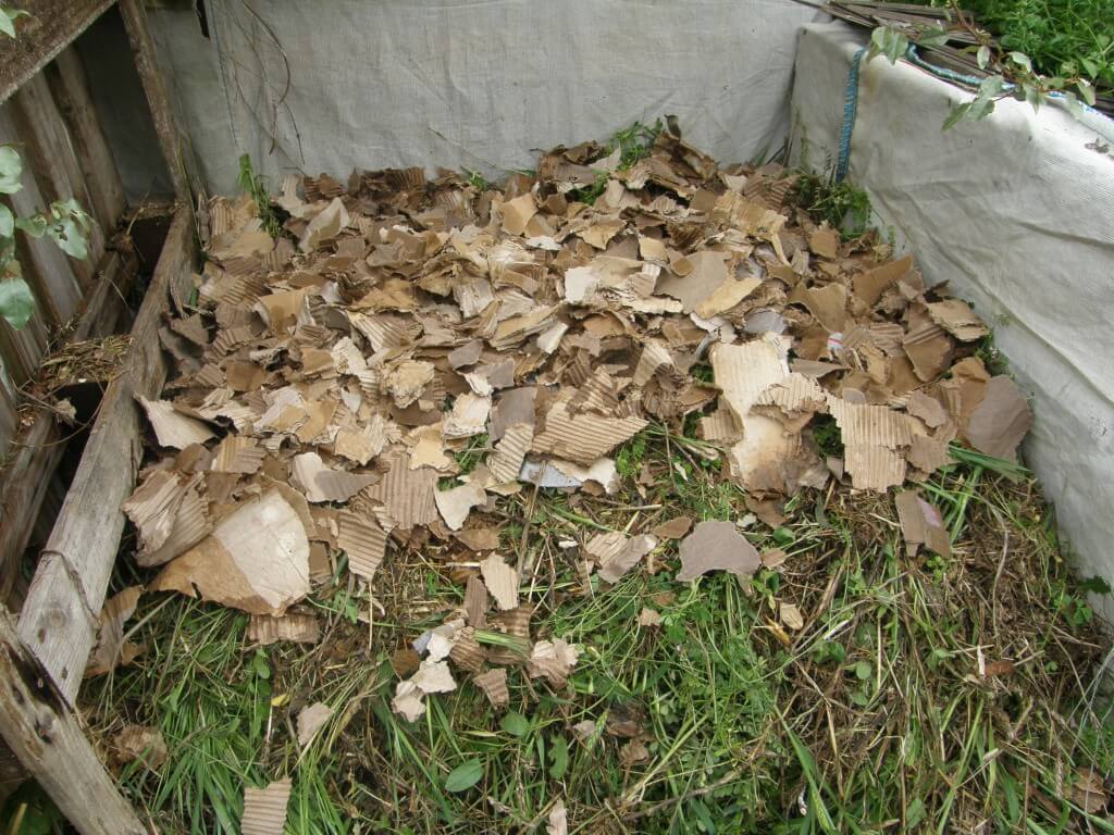 Compost : mise en œuvre. Les matières vertes et brunes sont mélangées, arrosées. Il n'y a plus qu'a attendre.